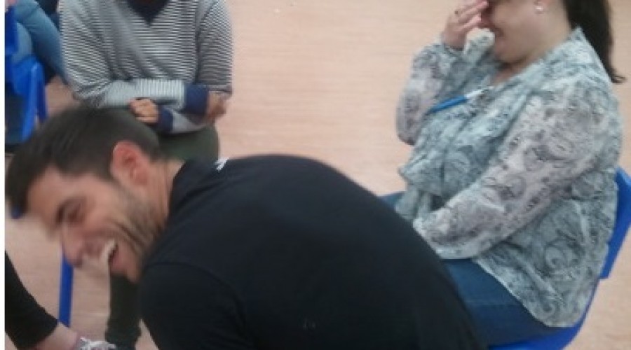a man turns away in hysterical laughter and his colleagues are laughing during a play exercise in a Play Skills for Staff workshop