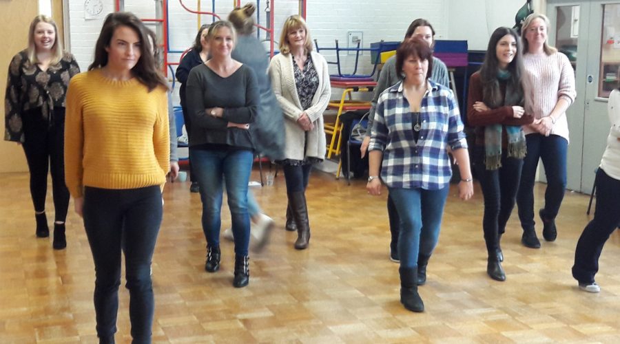 School staff playing a game of creeping forward towards a goal.