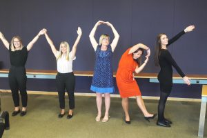 Women spelling out the word "work" as part of a team building london excercise